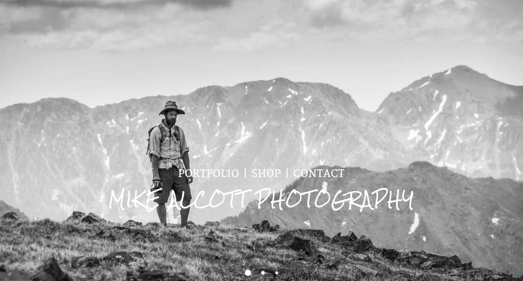 Man with backpack and hat overlooking mountain range, showcasing Mike Alcott Photography portfolio.